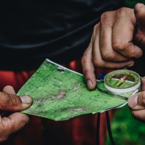 two person holding map and clear compass